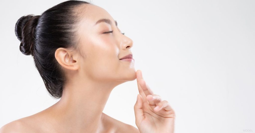 Asian woman gently touching her chin (MODEL)